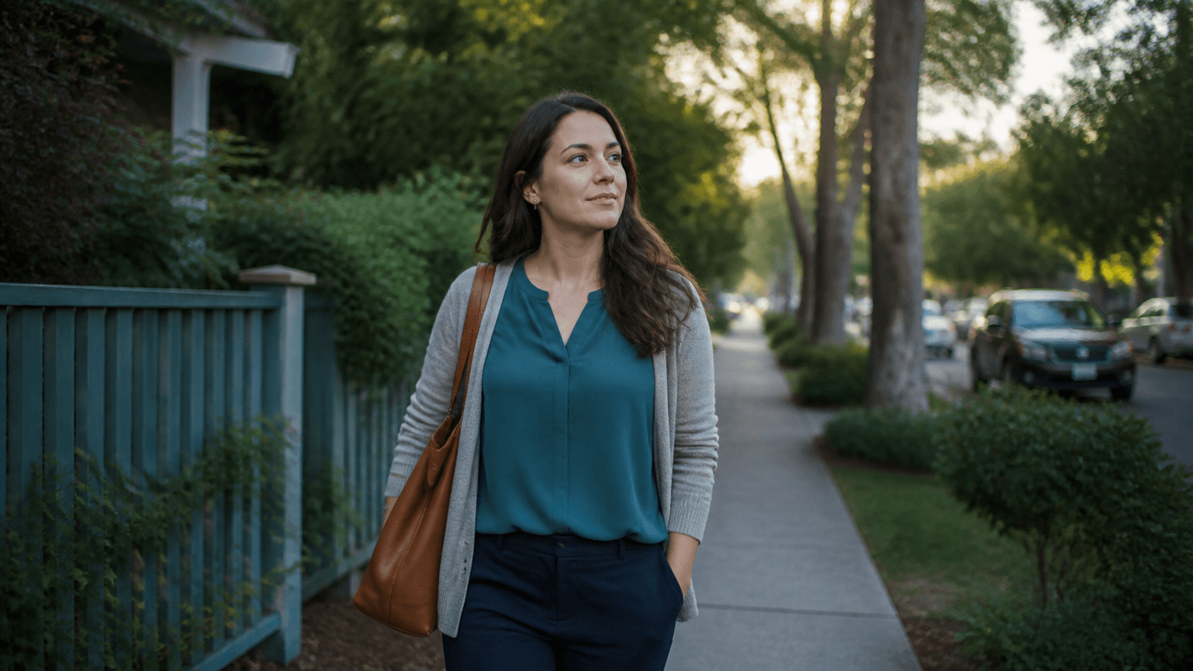 Eine Frau geht nach der Arbeit entspannt durch eine grüne Straße
