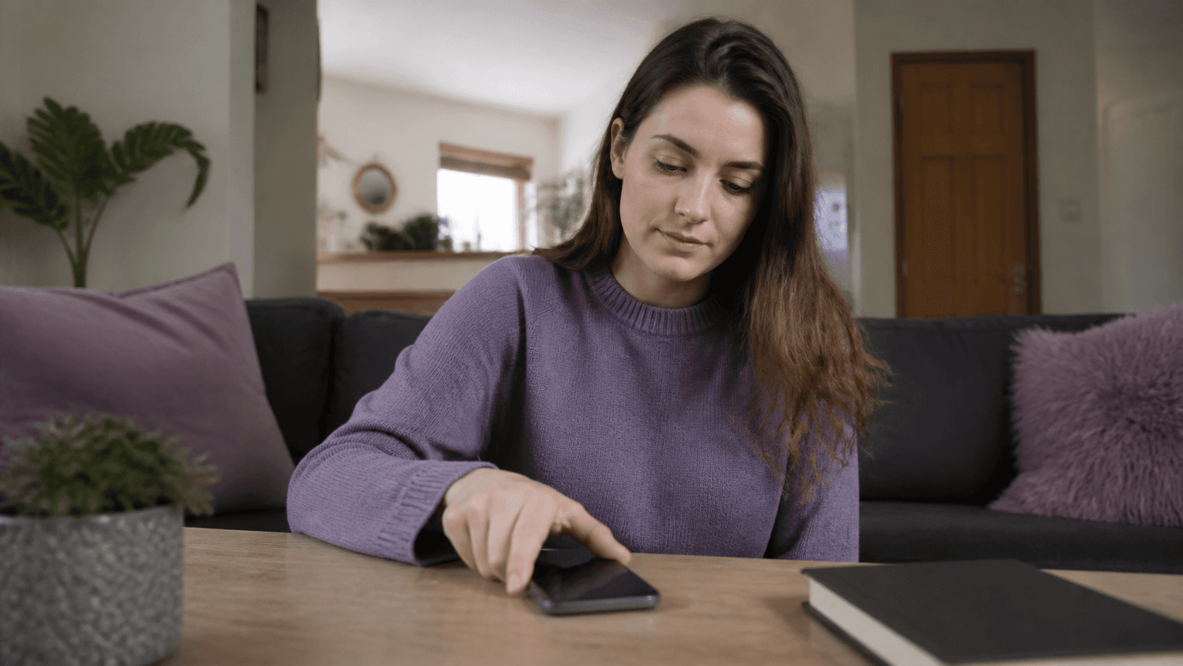Eine Frau legt ihr Smartphone bewusst auf den Tisch
